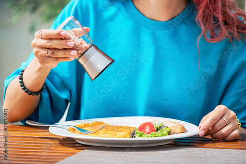 Tasty dishes in a cafe with added salt, highlighting culinary flavor but also concerns about excess sodium and health risks.