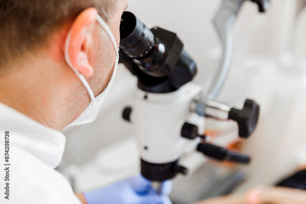 Dentist Using Microscope for Patient Examination Dentist Using Microscope for Patient Examination