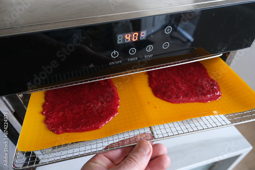 Fototapeta Naklejka Na Ścianę i Meble -  Preparation of a fruit leather, from blended and dehydrated raspberries.