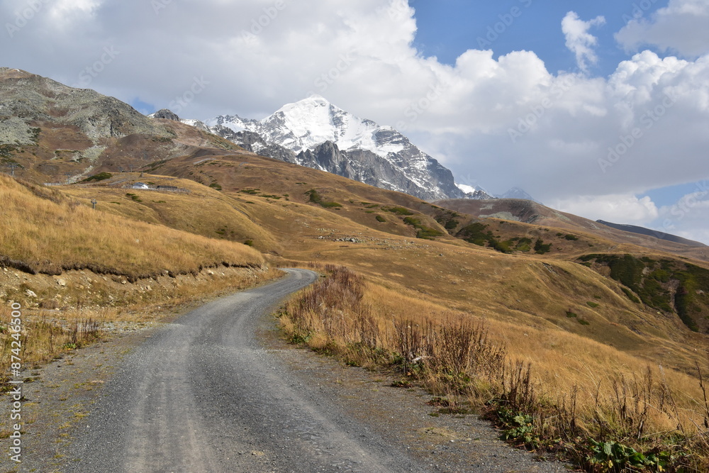 Winding dirt road leading towards the mountains Winding dirt road leading towards the mountains