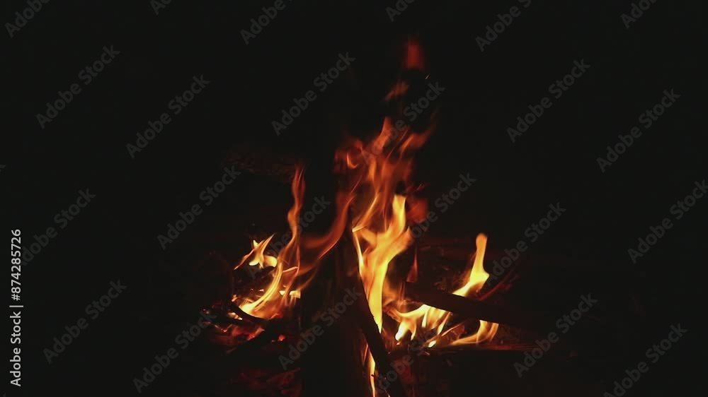 Close-up, flames. Night bonfire, logs are on fire, sparks fly. Close-up, flames. Night bonfire, logs are on fire, sparks fly.