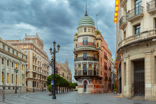 Old houses on Constitution Avenue in the light of lanterns at dawn, Seville, Andalusia, Spain