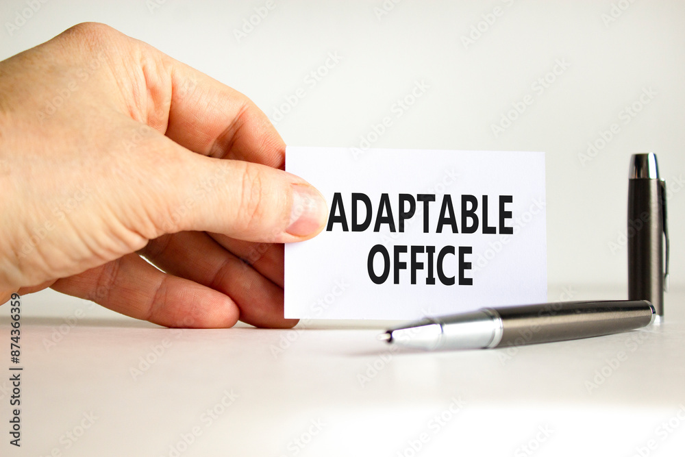 Adaptable office symbol. Concept words Adaptable office on beautiful white paper. Beautiful white background. Businessman hand. Business Adaptable office concept. Copy space. Adaptable office symbol. Concept words Adaptable office on beautiful white paper. Beautiful white background. Businessman hand. Business Adaptable office concept. Copy space.