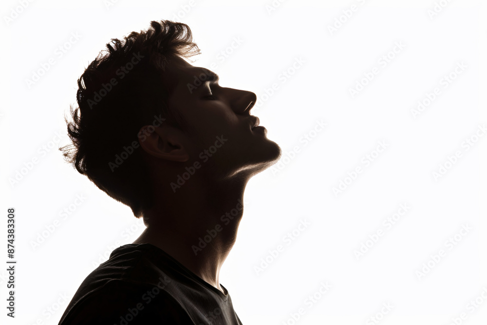 Silhouette of handsome man in black t-shirt on white background, isolated portrait of young guy with short hair and sidecut looking up, profile view, isolated


