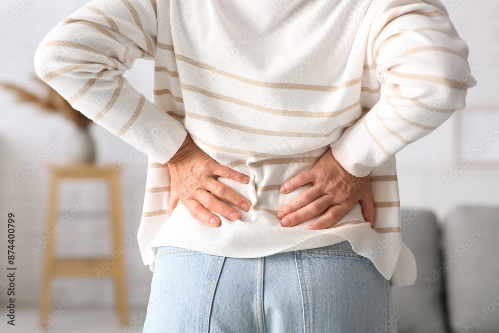 Fototapeta premium Mature woman suffering from back pain at home, closeup