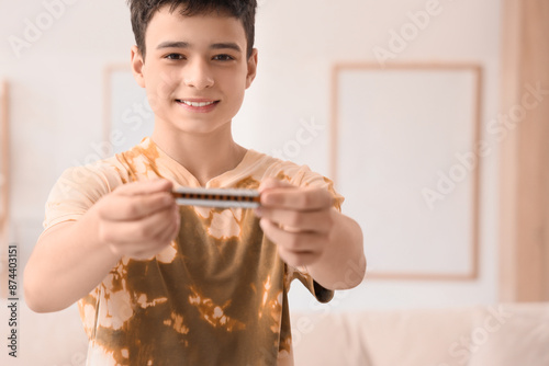 Teenage boy with harmonica ...