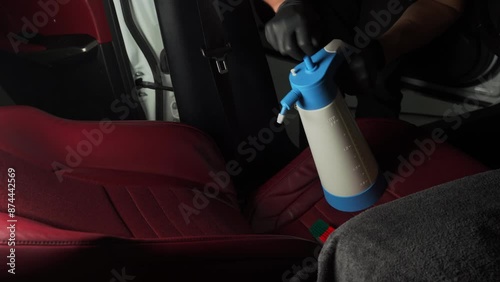 4k video process of splashing disinfector on car seatback. Detailing auto seats using special spray of detergent. photo