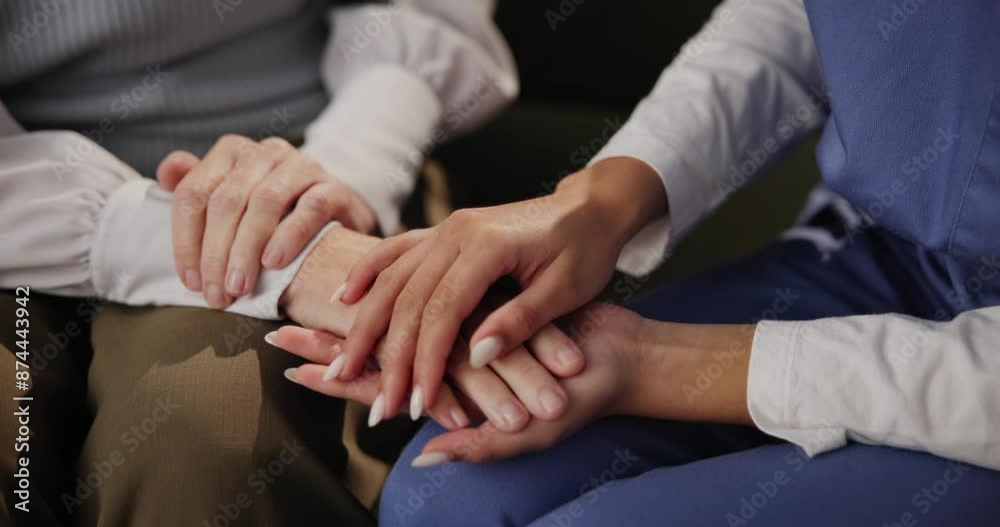 Patient, nurse and holding hands for support, comfort and helping with medical news or healthcare on sofa. People and worker, doctor or caregiver with advice, kindness and empathy at nursing home Patient, nurse and holding hands for support, comfort and helping with medical news or healthcare on sofa. People and worker, doctor or caregiver with advice, kindness and empathy at nursing home