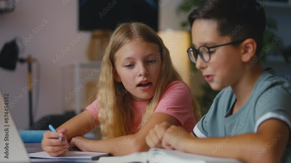 Young boy and girl getting ready for school test, writing in notebook, studying