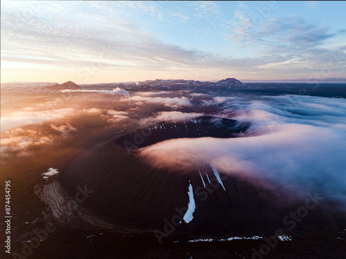 View from above, stunning aerial view of Hverfjall volgano at sunset surrounded by beautiful fluffy clouds. Hverfjall is a fascinating volcano near Lake Mývatn, with a crater approximately 1 km wide.