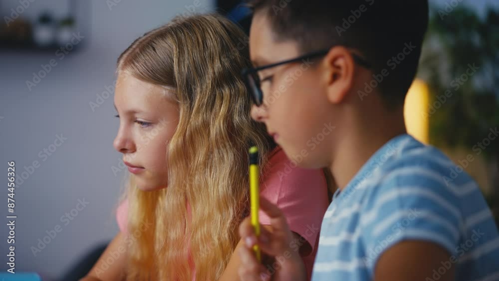Thoughtful boy and girl working on school project using laptop, homeschooling Thoughtful boy and girl working on school project using laptop, homeschooling