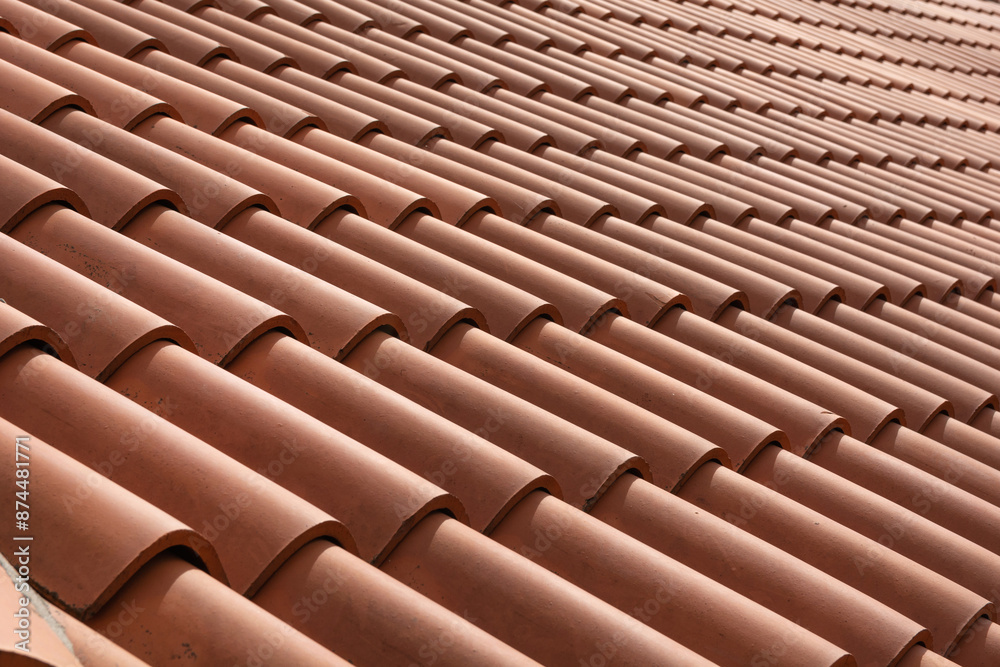 Red corrugated roof tile element on a house on a sunny day. Shingles roofing surface tiles overlay pattern and texture.