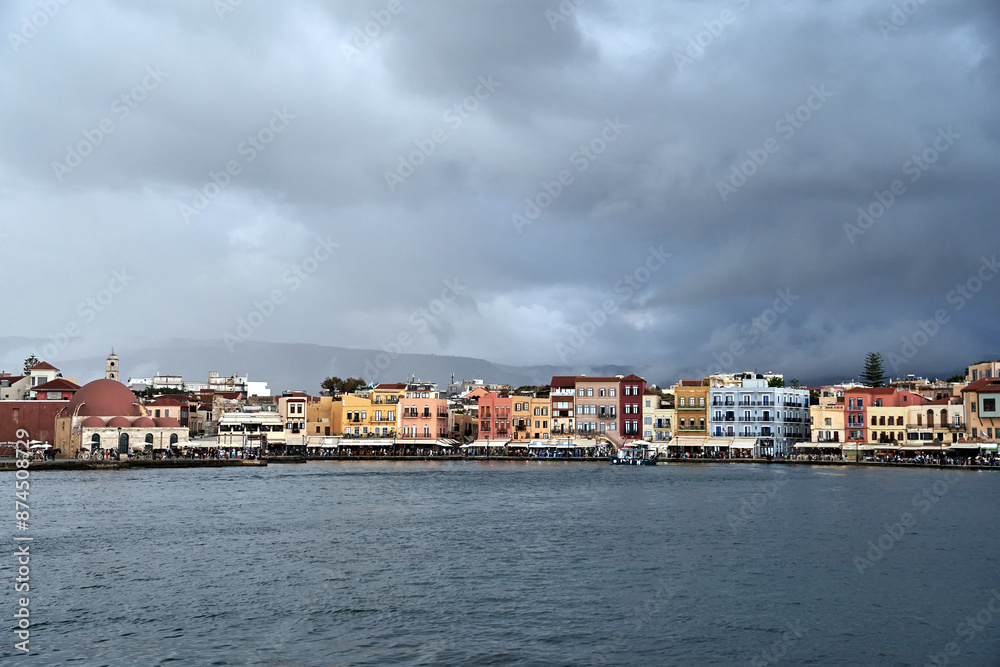 Taverns, historic buildings and crowds of tourists in the port of Chania on the island of Crete Taverns, historic buildings and crowds of tourists in the port of Chania on the island of Crete