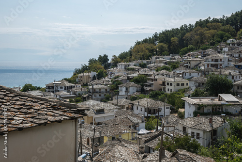 A view of the stone roofs and close-knit houses of the village of Panagia on the island of Thassos. The sea can be seen in the distance. photo