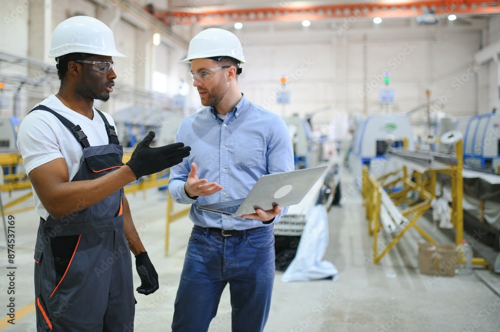Two workers at a factory for the production of plastic windows. Engineer and worker on the production line Two workers at a factory for the production of plastic windows. Engineer and worker on the production line