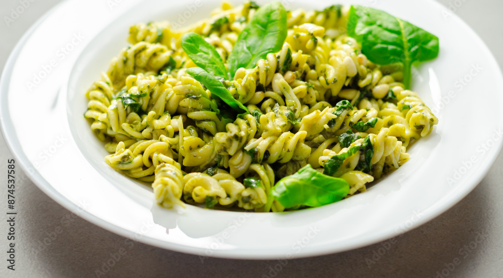 A plate of pasta with spinach on top A plate of pasta with spinach on top