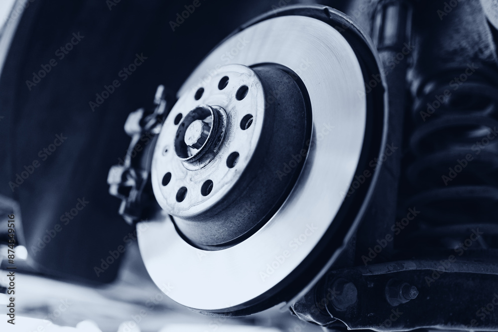 Closeup steel brake disk and detail of wheel hub with sunlight. Concept replacing wheel pads in garage car service Closeup steel brake disk and detail of wheel hub with sunlight. Concept replacing wheel pads in garage car service