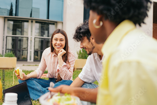 Portrait of beautiful latin student sitting on campus with her friends after class.