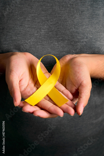 Female hands hold yellow suicide prevention day banner symbolizing hope