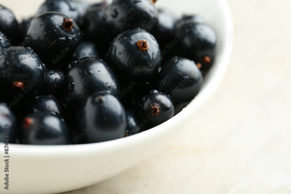 Ripe black currants in bowl on light table, closeup Ripe black currants in bowl on light table, closeup