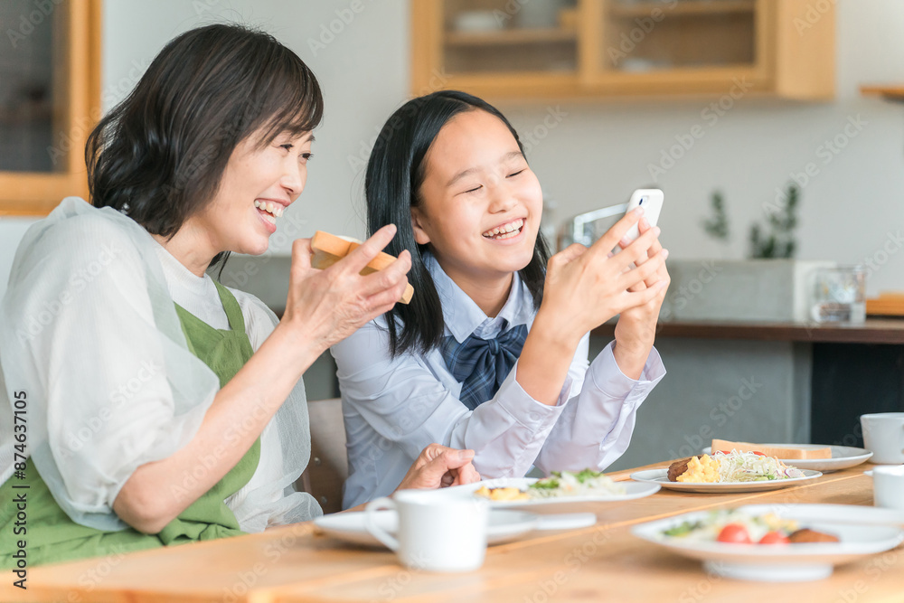 ママと一緒にスマホ・スマートフォンを見る子供・中学生・高校生
