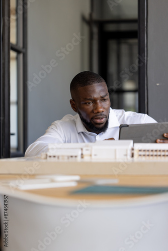 Reviewing building model on tablet, architect working in office photo