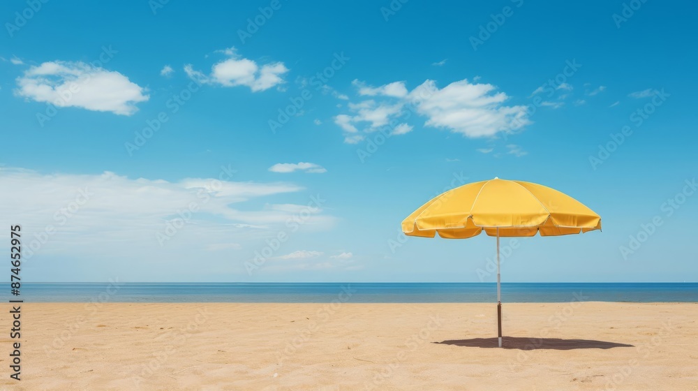 A single yellow umbrella on a vast, empty sandy beach with clear blue skies above A single yellow umbrella on a vast, empty sandy beach with clear blue skies above