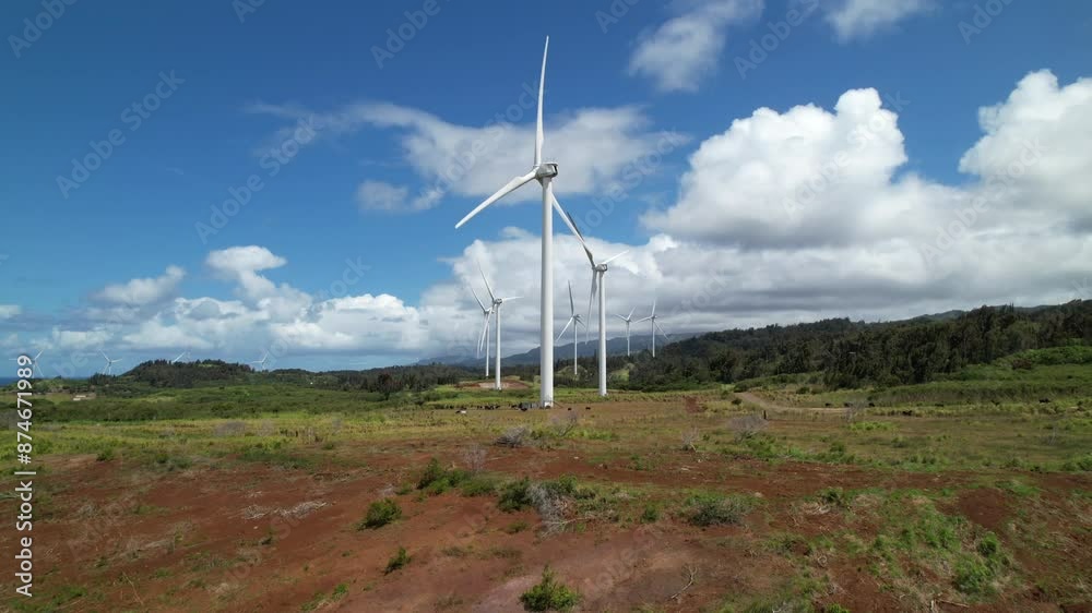 Large white wind turbine in rural countryside of Hawaii with cows grazing at base. Drone shot slow push in towards wind farm. Large white wind turbine in rural countryside of Hawaii with cows grazing at base. Drone shot slow push in towards wind farm.
