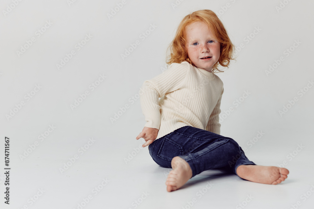 Happy little girl sitting on floor with smile on face in a cheerful moment of joy and innocence Happy little girl sitting on floor with smile on face in a cheerful moment of joy and innocence