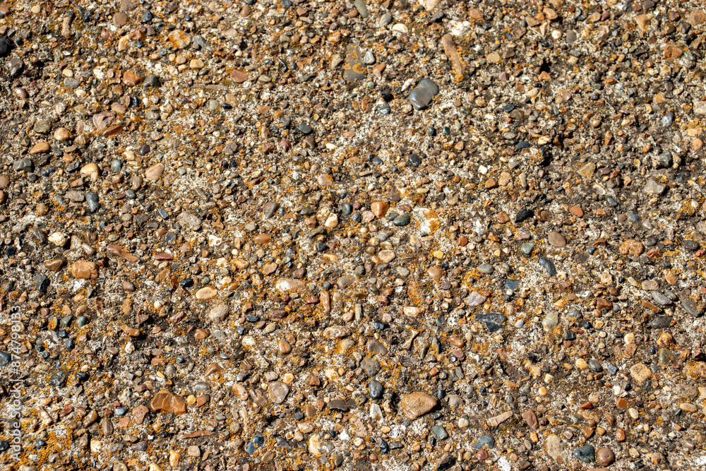 Large and small pebbles on the surface of concrete, top view. Various-sized pebbles, flat layout. Pebbles of different sizes lie chaotically. Large and small pebbles on the surface of concrete, top view. Various-sized pebbles, flat layout. Pebbles of different sizes lie chaotically.