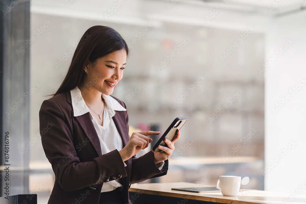Beautiful young millennial Asian woman using a smartphone at a cafe. Portrait of a gorgeous smiling female engrossed in her mobile phone. Beautiful young millennial Asian woman using a smartphone at a cafe. Portrait of a gorgeous smiling female engrossed in her mobile phone.