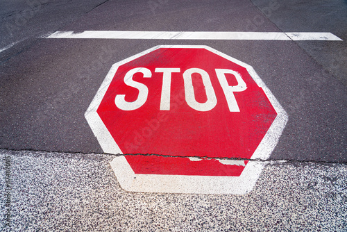 An octagonal red stop sign with white capital letters 