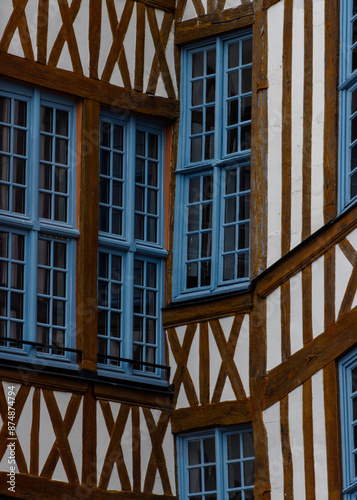Façade de maison à colombages avec fenêtres bleues en bois