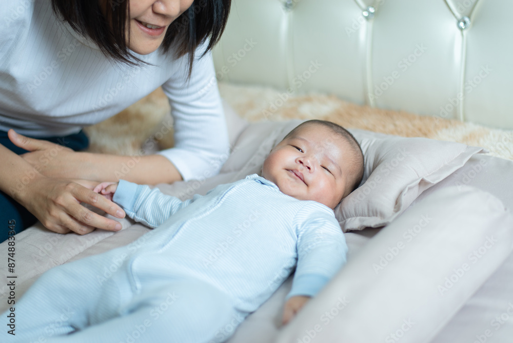 Adorable asian baby boy relaxing with mom on bed,Newborn child Adorable asian baby boy relaxing with mom on bed,Newborn child