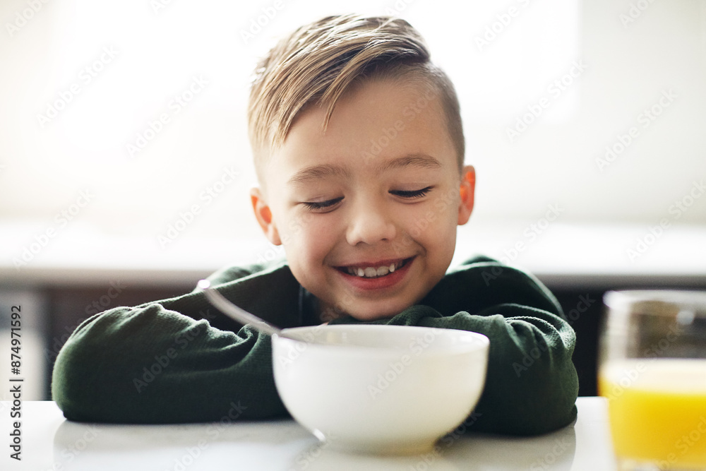 Breakfast, child and smile in kitchen for nutrition, vitamins and development for health. Happy, boy or kid and bowl for morning with orange juice or cereal for growth and wellness on weekend in home Breakfast, child and smile in kitchen for nutrition, vitamins and development for health. Happy, boy or kid and bowl for morning with orange juice or cereal for growth and wellness on weekend in home
