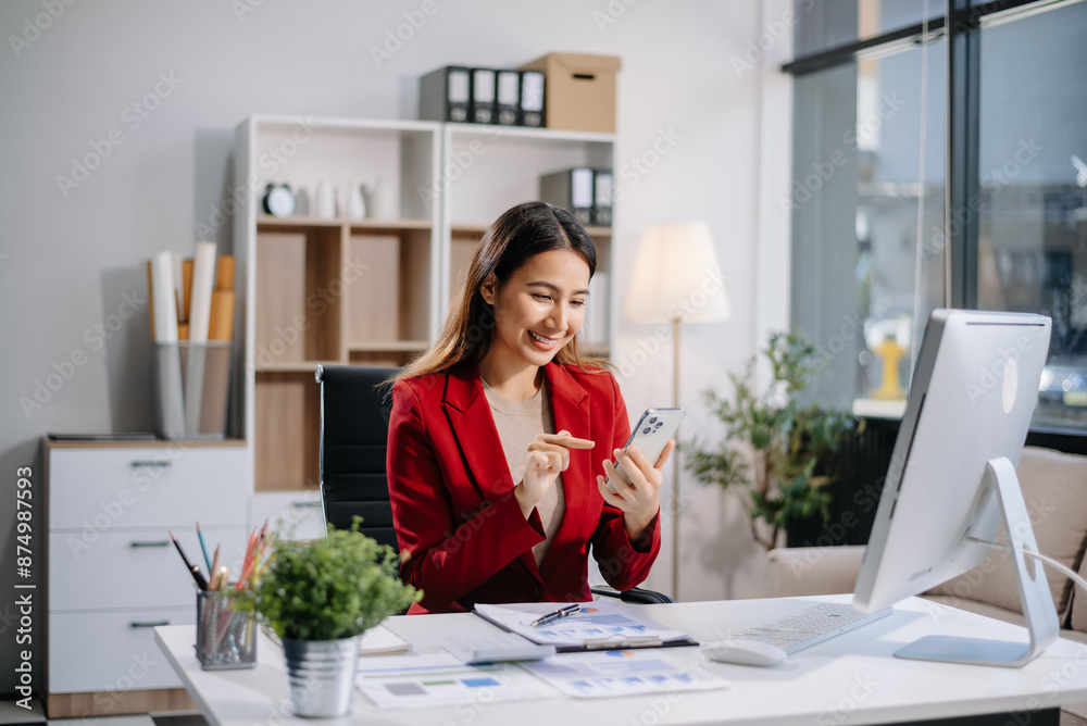 Young beautiful woman typing on tablet and laptop while sitting at the working white table in modern office Young beautiful woman typing on tablet and laptop while sitting at the working white table in modern office