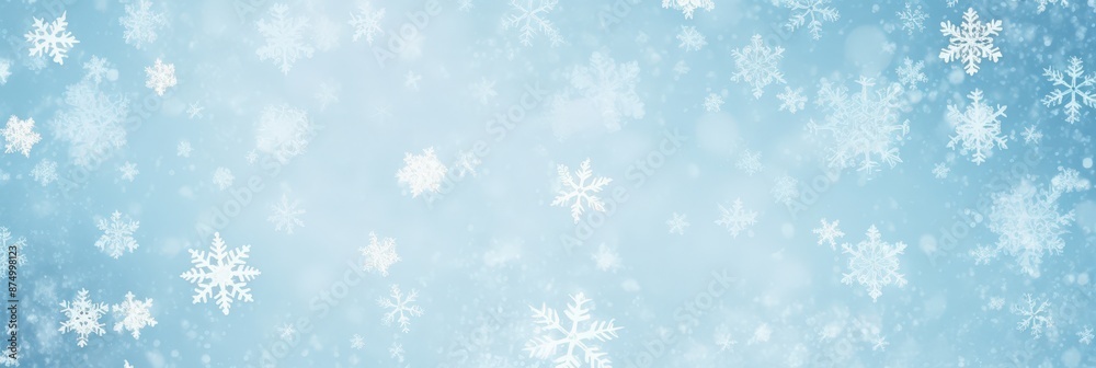 Delicate snowflakes gently falling against a pale blue winter sky background Delicate snowflakes gently falling against a pale blue winter sky background