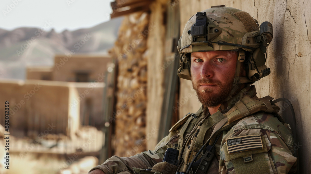 A portrait of a resolute american soldier in full gear, posing with his rifle against a wall A portrait of a resolute american soldier in full gear, posing with his rifle against a wall