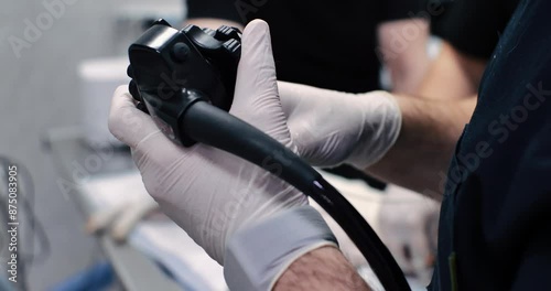 A doctor's hand holds the path of controlling an endoscope during a gastroscopic examination of a pet in veterinary surgery. Gastroscopic examination of the animal's digestive system. photo