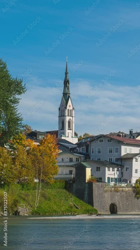 Time lapse of golden autumn in famous tourist landmark town Bad Tolz. Landscape view of Isar river, trees, town bridge, idyllic Bavarian houses and Church. Bad Toelz, Bavaria, Germany. Camera zoom in Time lapse of golden autumn in famous tourist landmark town Bad Tolz. Landscape view of Isar river, trees, town bridge, idyllic Bavarian houses and Church. Bad Toelz, Bavaria, Germany. Camera zoom in