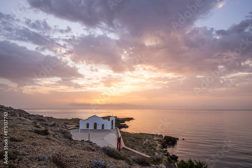 Small white church in the typical architectural style of Greece. She stands on a tree surrounded by the Mediterranean and in the sunrise.
Chapel of Agios Nikolaos, Ionian Islands, Greece photo