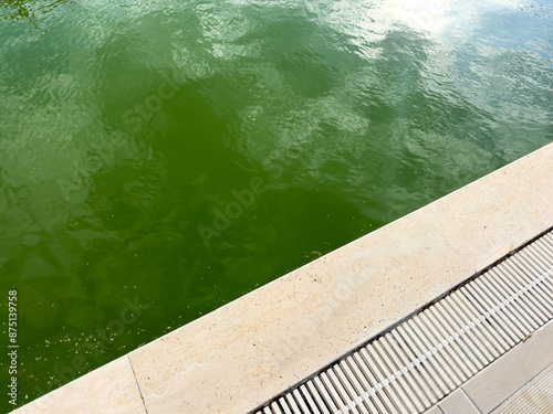 Swimming pool maintenance, dirty pool, Swimming pool with dirty green water close-up.