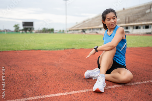 Happy Mature fitness Asia woman runner stretching before run on racetrack  © chachamp
