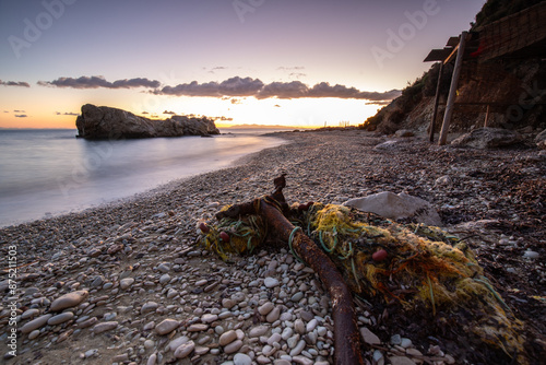 Hidden bay in sunrise. Looked at the small sand, pebble, beach in warm colors and the morning light. View of the sea at Xigia Sulfur Beaches, Ionian Islands, Greece photo