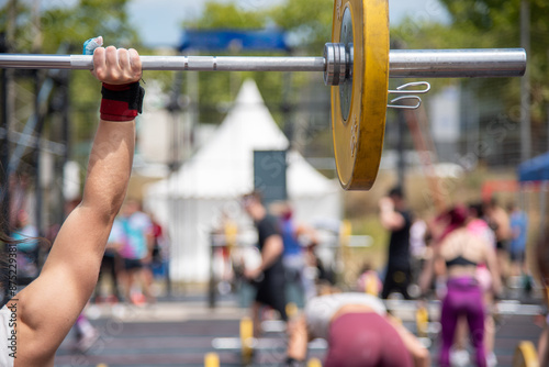 Outdoor weightlifting competition with athletes in full action and dynamic environment.