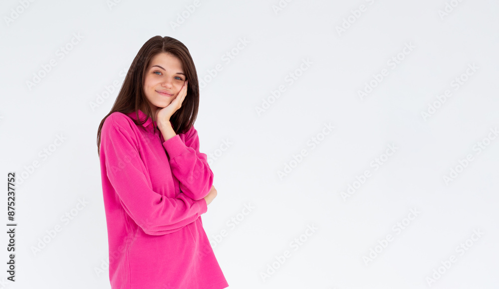 Portrait of young stylish girl smiling with hand on cheek looking at camera. Copy space. Isolated on white Portrait of young stylish girl smiling with hand on cheek looking at camera. Copy space. Isolated on white