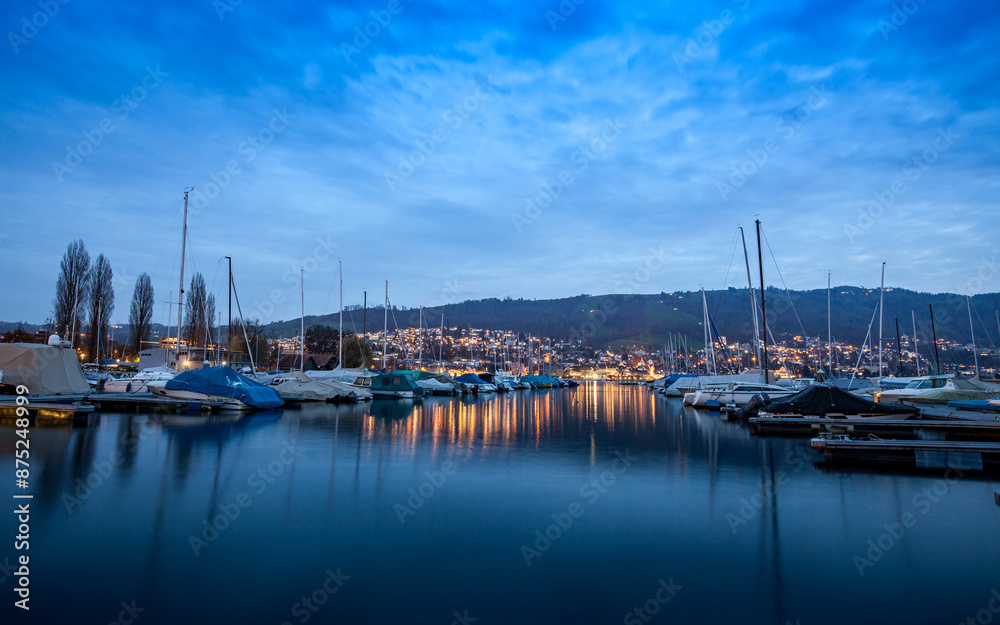 The harbor of Zug with sailing ships on a cold winter evening The harbor of Zug with sailing ships on a cold winter evening