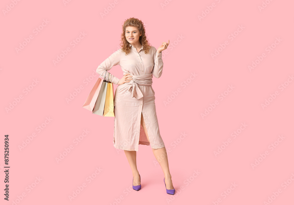Beautiful young woman in stylish beige dress with shopping bags on pink background Beautiful young woman in stylish beige dress with shopping bags on pink background