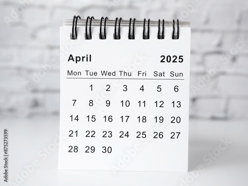 April 2025 white monthly desk calendar on a table