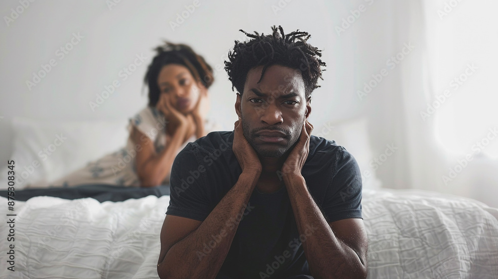 Obraz premium Couple have a problem in the bedroom a man sitting on the edge of the bed with his wife in the back unsatisfied